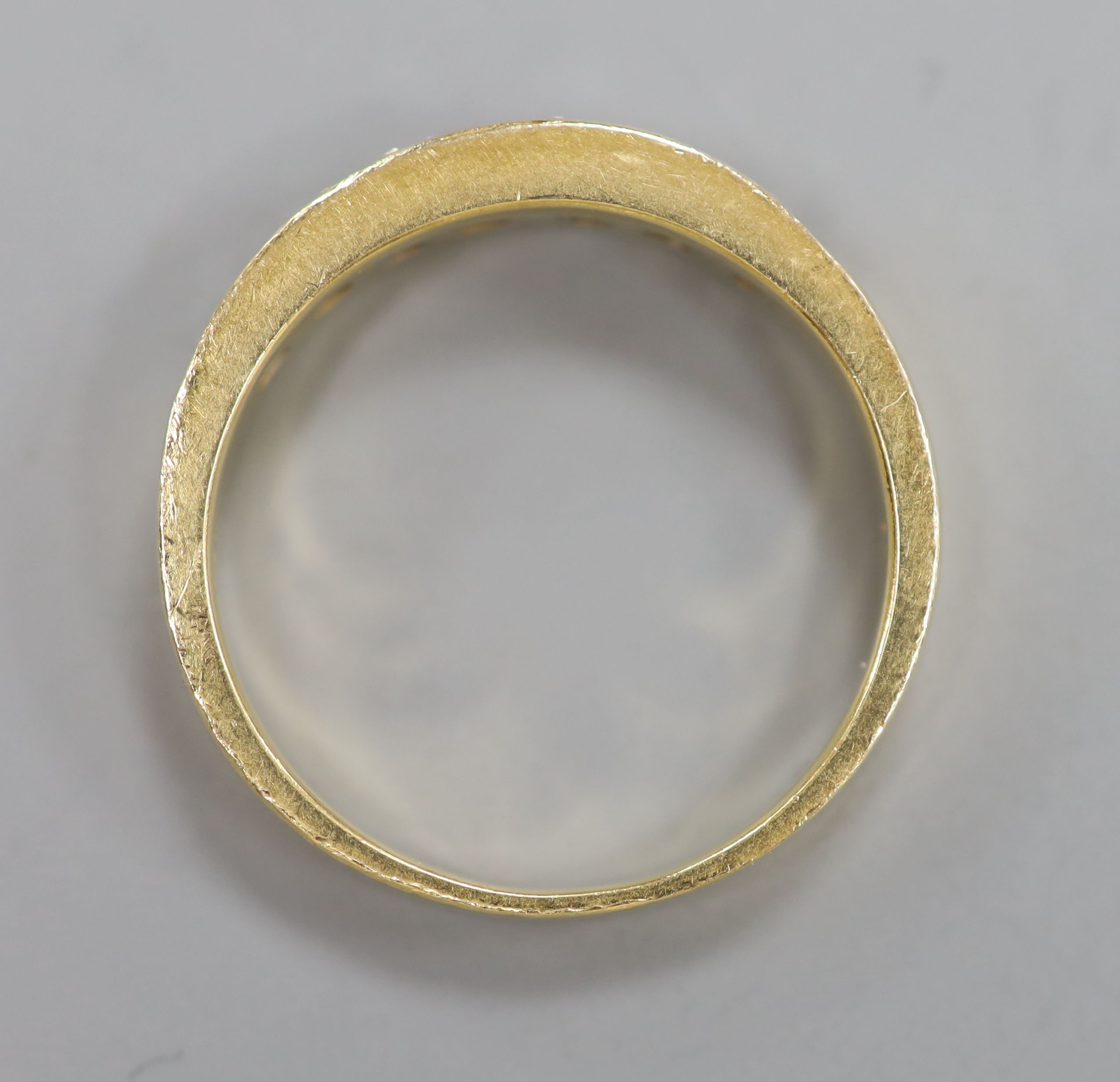 A modern 750 yellow metal and channel set seven stone diamond half hoop ring, size N, gross 3.9 grams.
